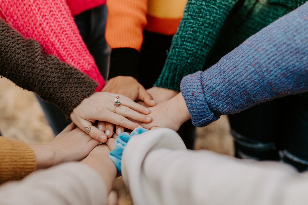 A circle of hands stacked together in a group huddle